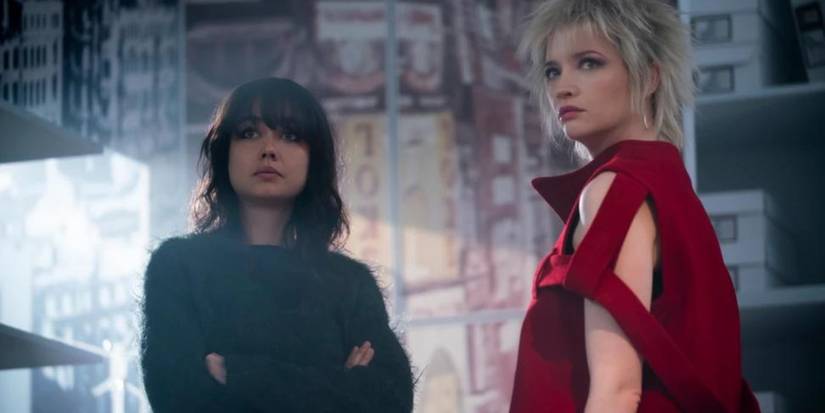 Chrissie (Sydney Chandler) e Vivienne Westwood (Talulah Riley) em pé em pistola.