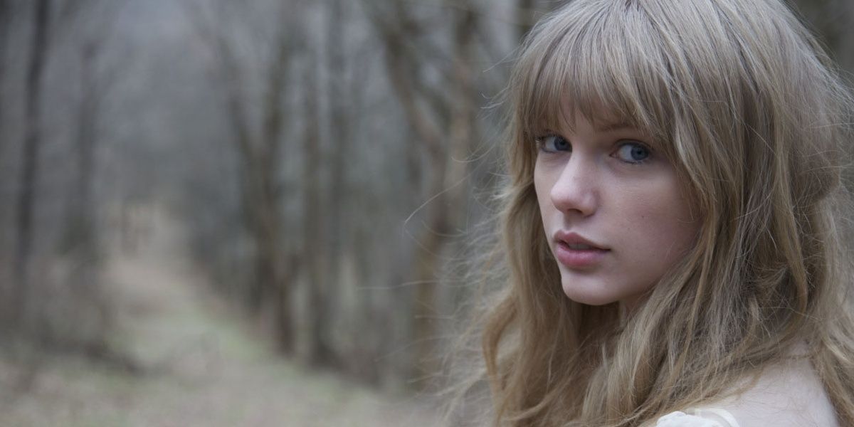 Taylor Swift looking back while walking in a forest in the video for Safe Sound Cropped