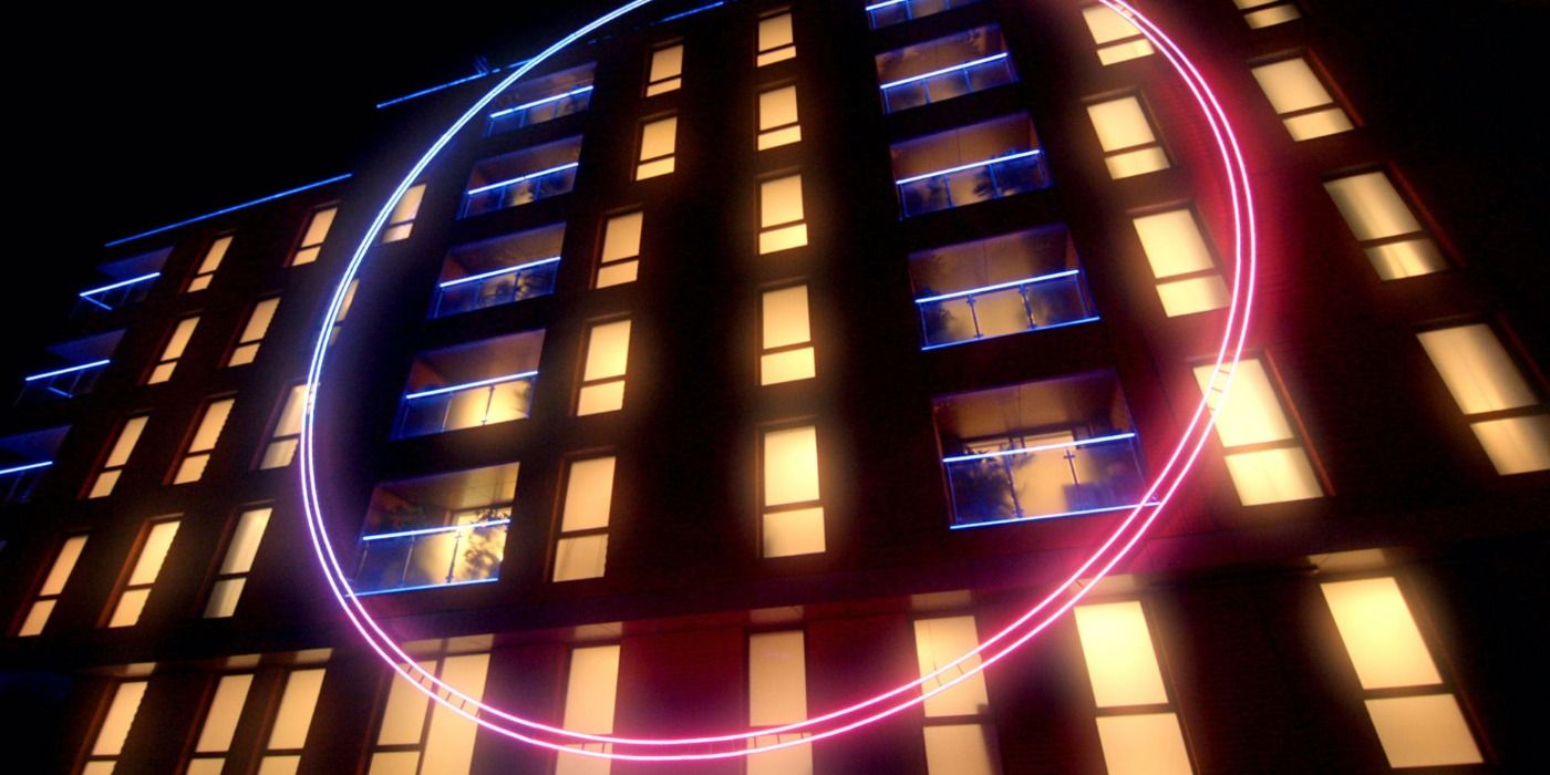 Apartment building with neon pink and blue circle, set of Netflix's The Circle.