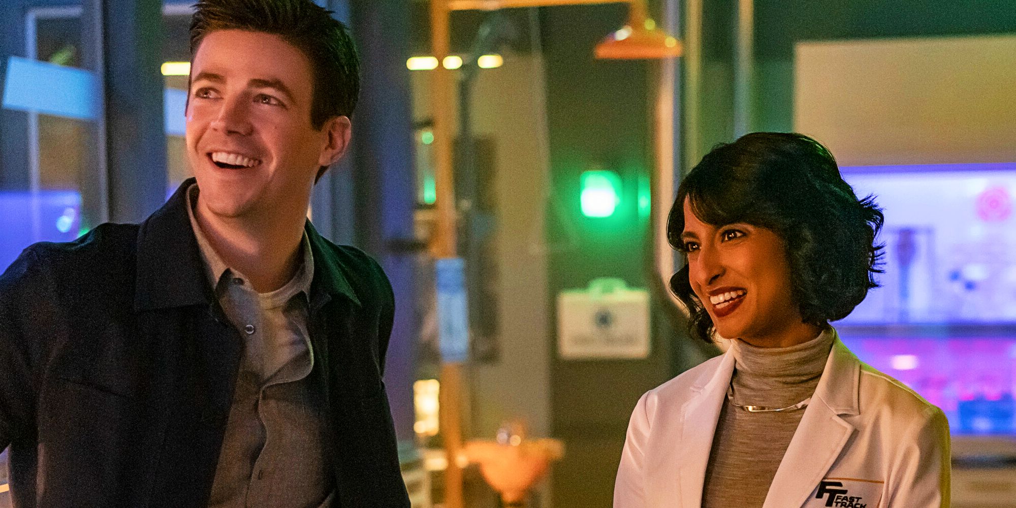 The Flash Grant Gustin as Barry Allen and Kausar Mohammed as Meena Dhawan smiling in lab
