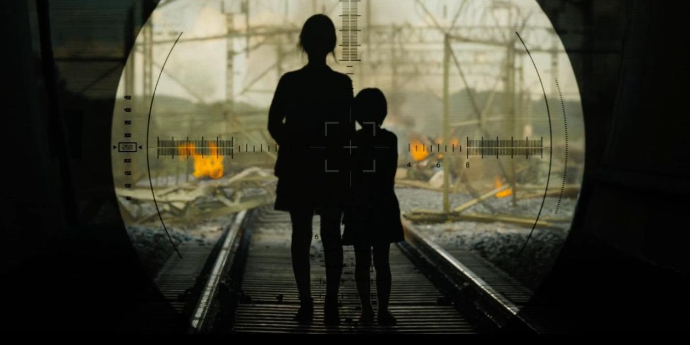 A woman and a child walking on train tracks as seen through a sniper rifle in Train to Busan.