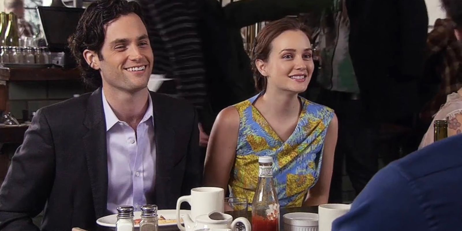 Dan e Blair sorriem na mesa de jantar em Gossip Girl.