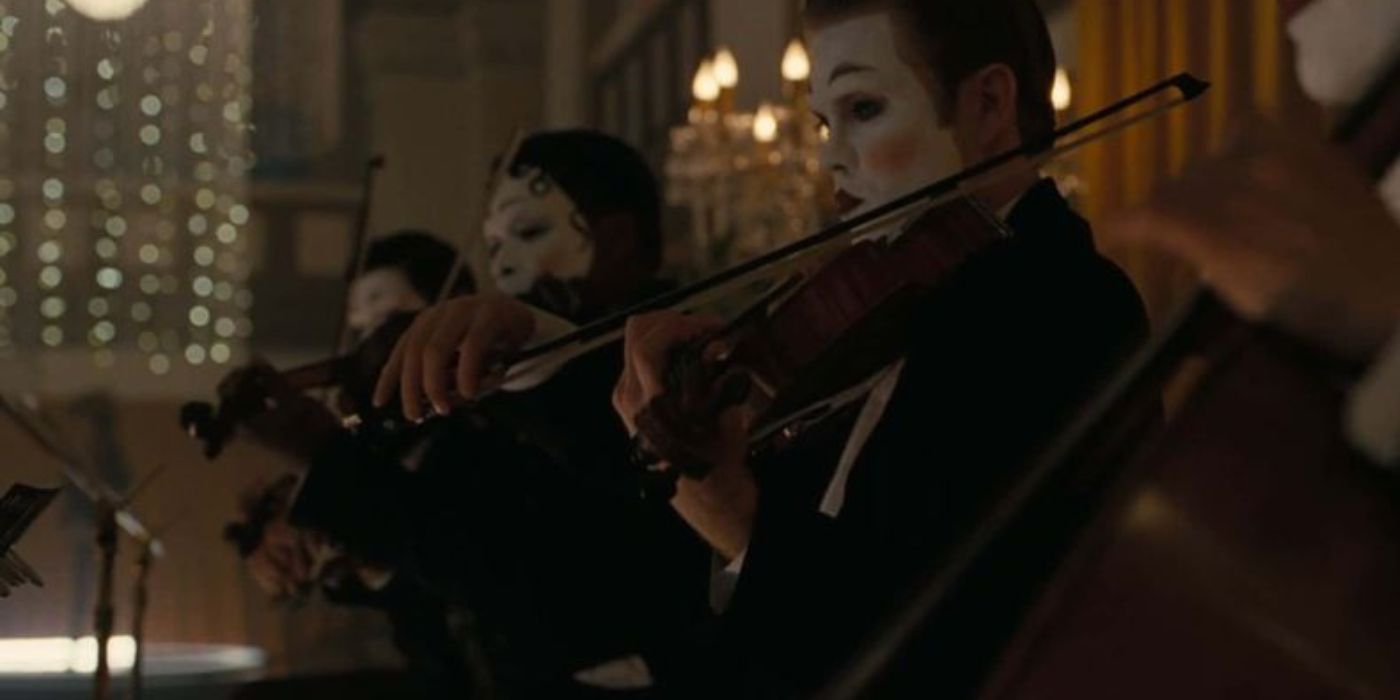 Violinists playing violin and wearing facepaint in a still from Westworld