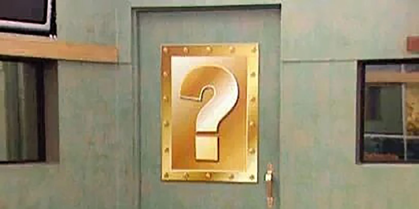 An oversized question mark on a door indicating a twist on Big Brother.
