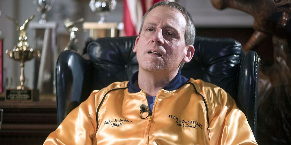 Du Pont wears a gold jacket at his desk in Foxcatcher