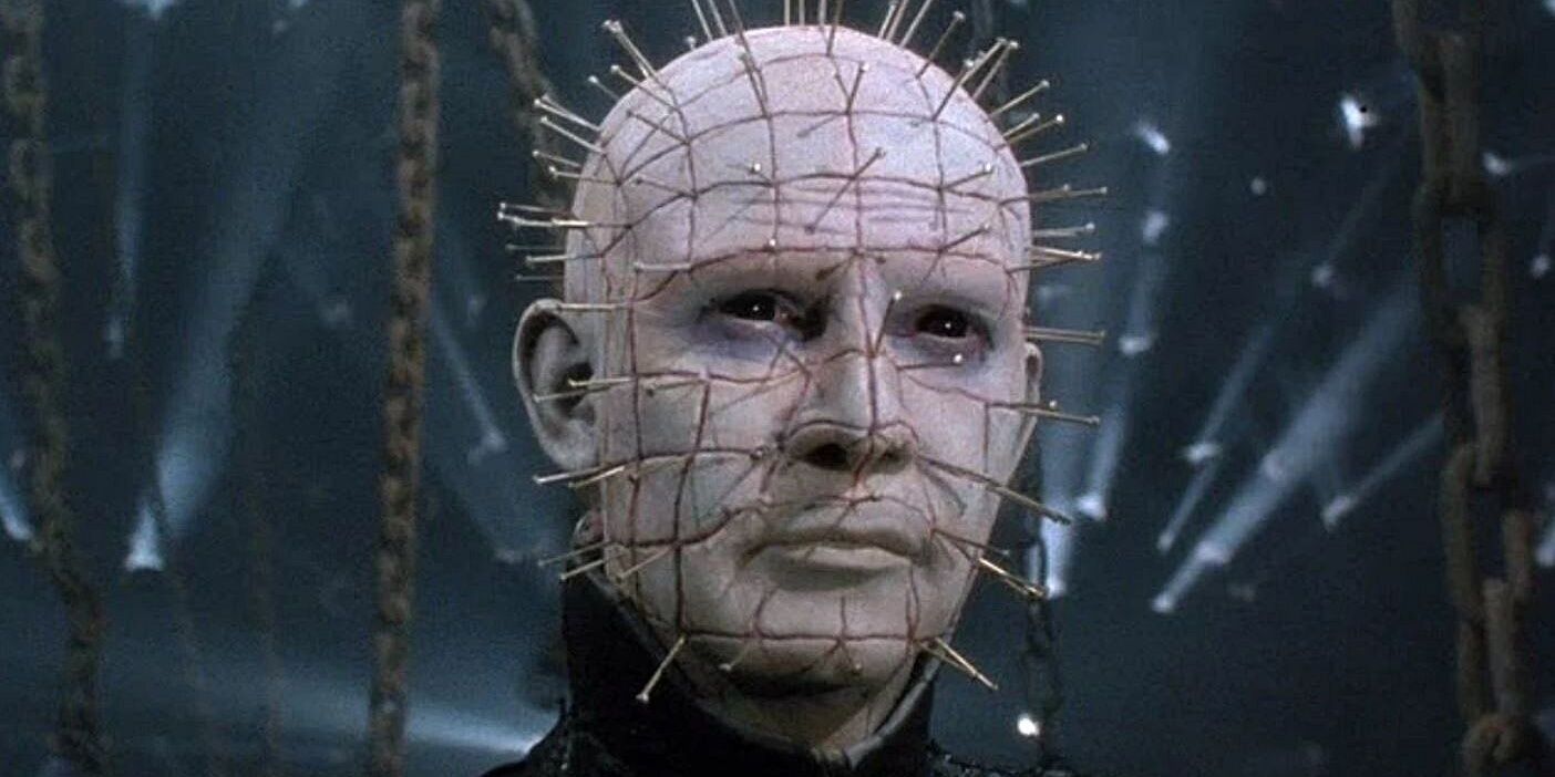 Pinhead standing menacingly, with many chains behind him.