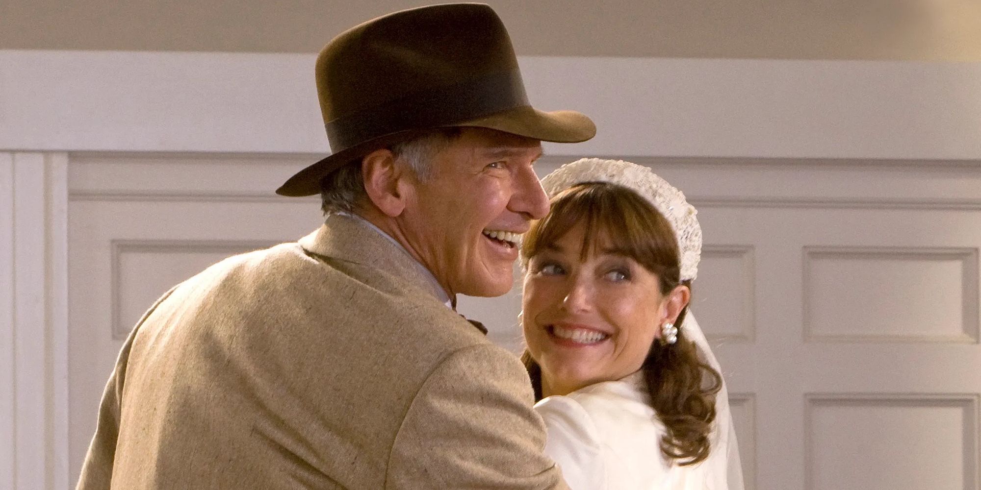 Indiana Jones and Marion look over their shoulders and smile.