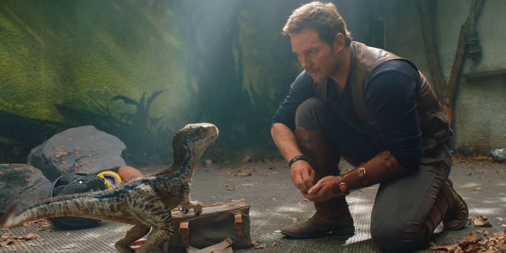 Grady kneels beside a young dinosaur in Jurassic World: Fallen Kingdom
