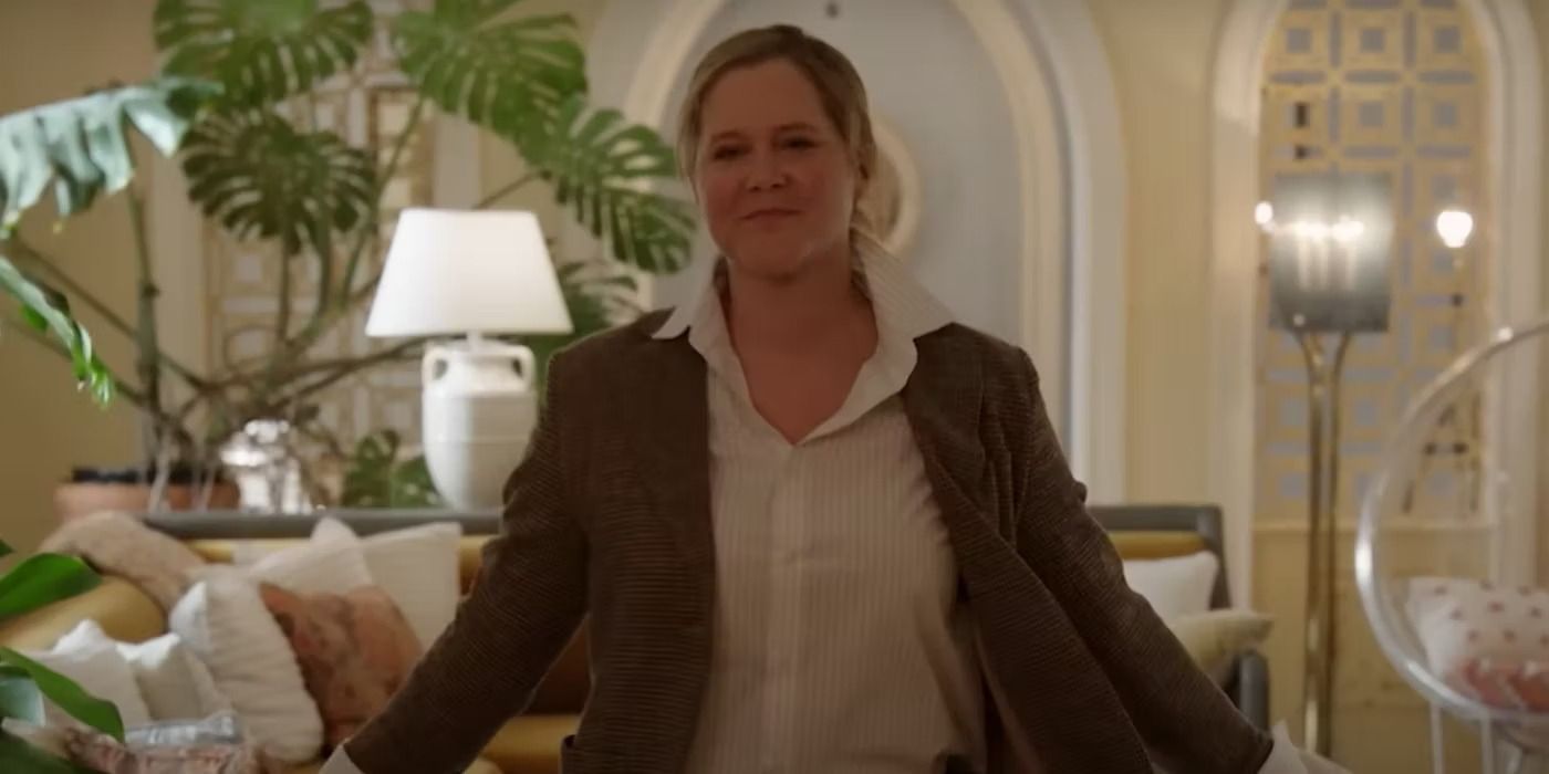 Amy Schumer standing at the front door of her apartment, smiling in a scene from Only Murders in the Building.