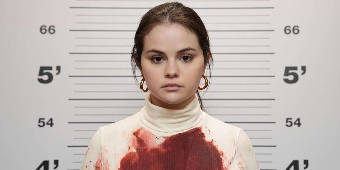Mabel's mugshot from Only Murders in the Building, blood soaking through her white turtleneck.