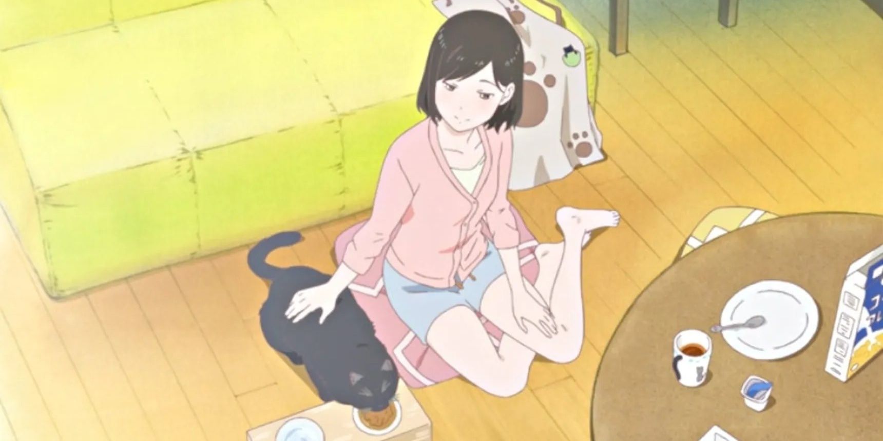 She petting Daru the cat as he eats on the living room floor in She and Her Cat.