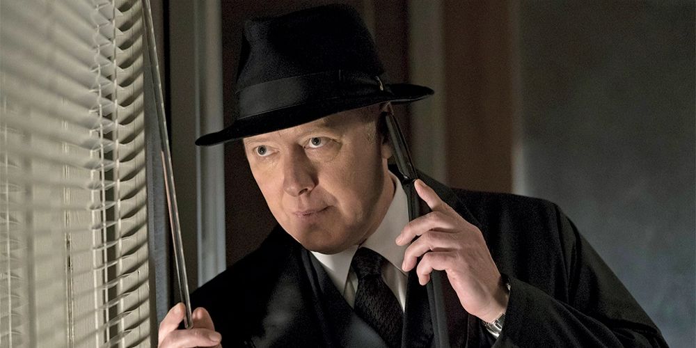 Red draws the blinds and talks on the phone in The Blacklist