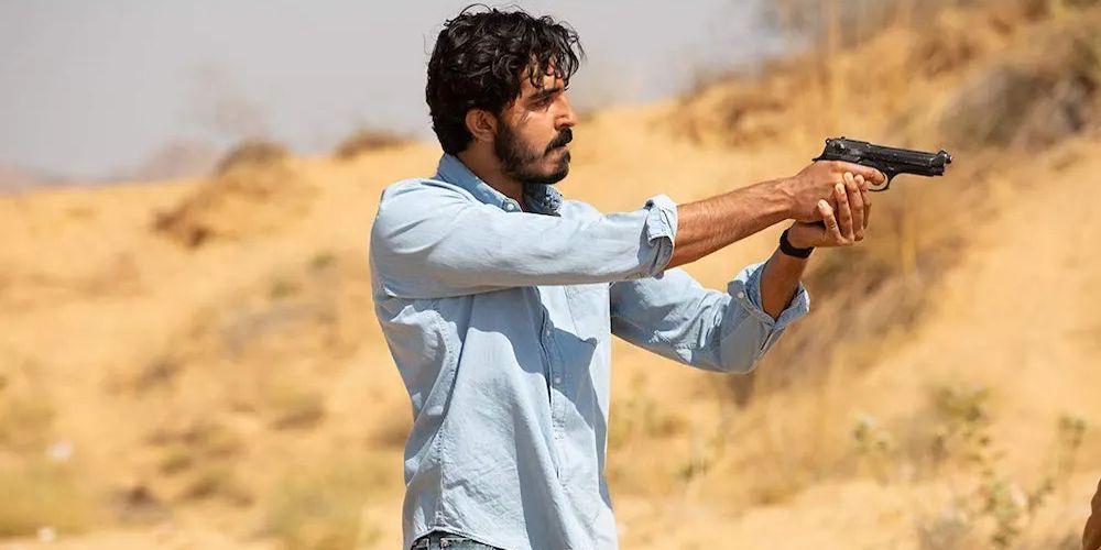 Jay aims a gun in the desert in The Wedding Guest
