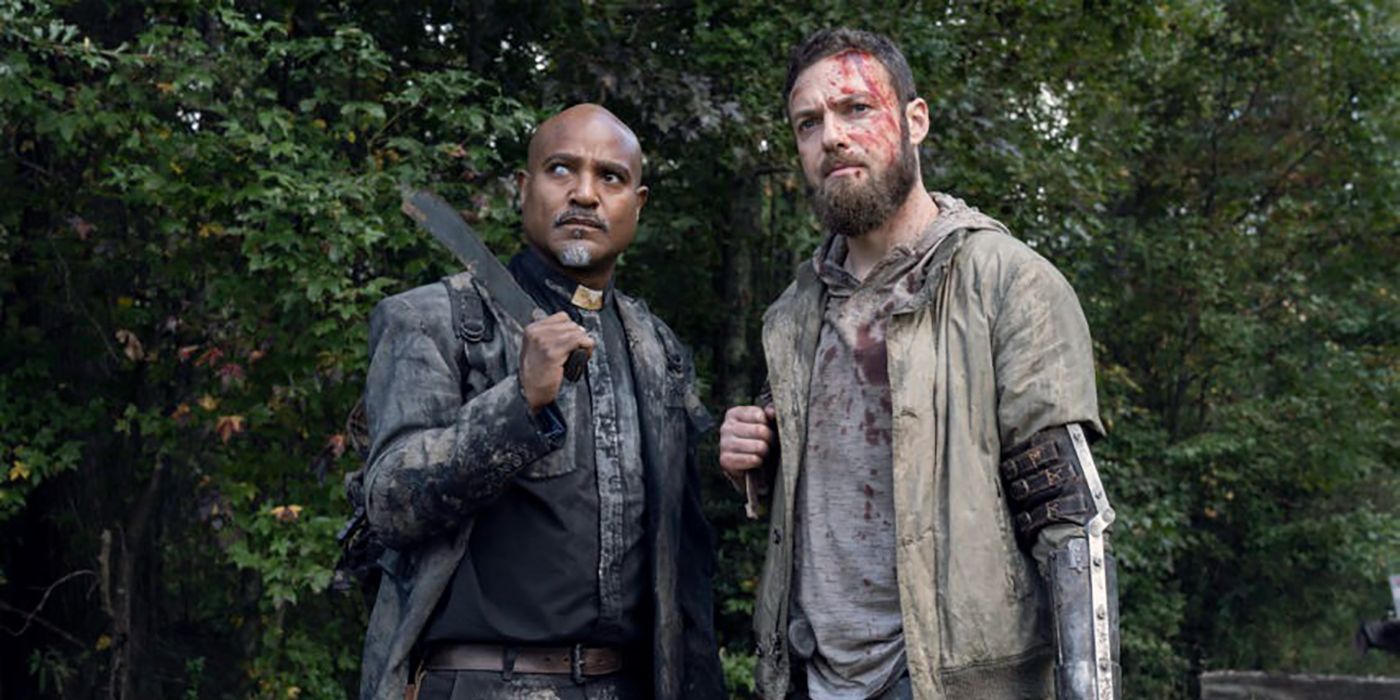 Gabriel and Aaron from The Walking Dead standing together in the forest.