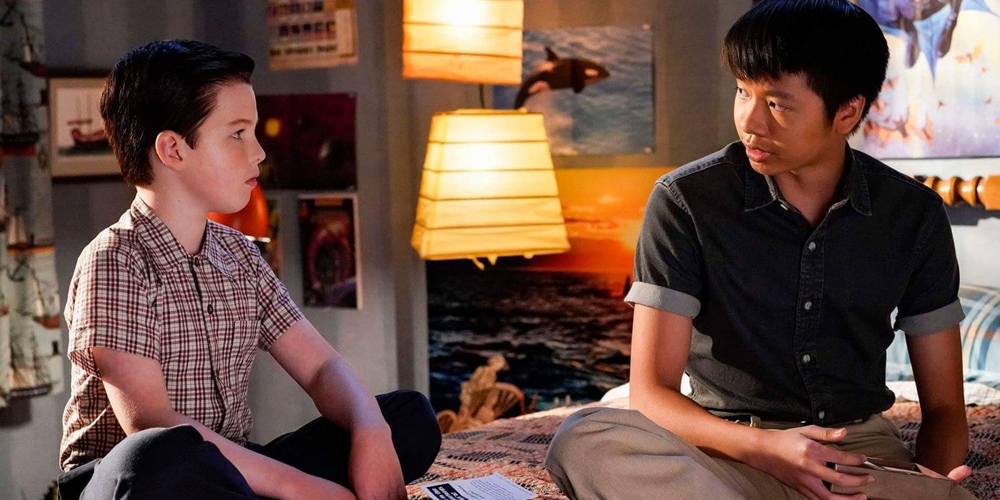 Sheldon and Yam sitting on Sheldon's bed in Young Sheldon, talking.