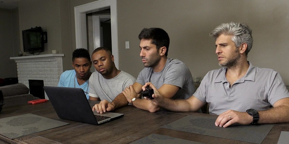 Cropped Nev, Max, Dejay and Malik looking at a laptop.