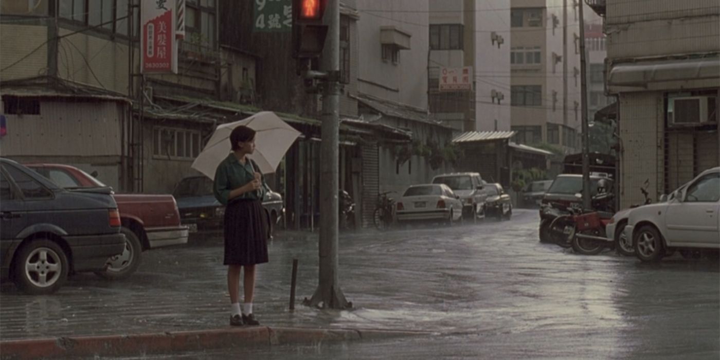 A young girl standing under the rain with an umbrella in the 2000 movie Yi Yi.