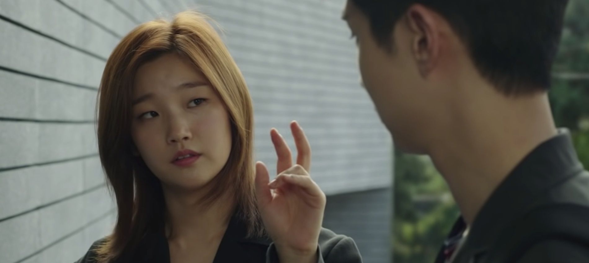 An image of Kim Ki-jung holding her hand up in Parasite