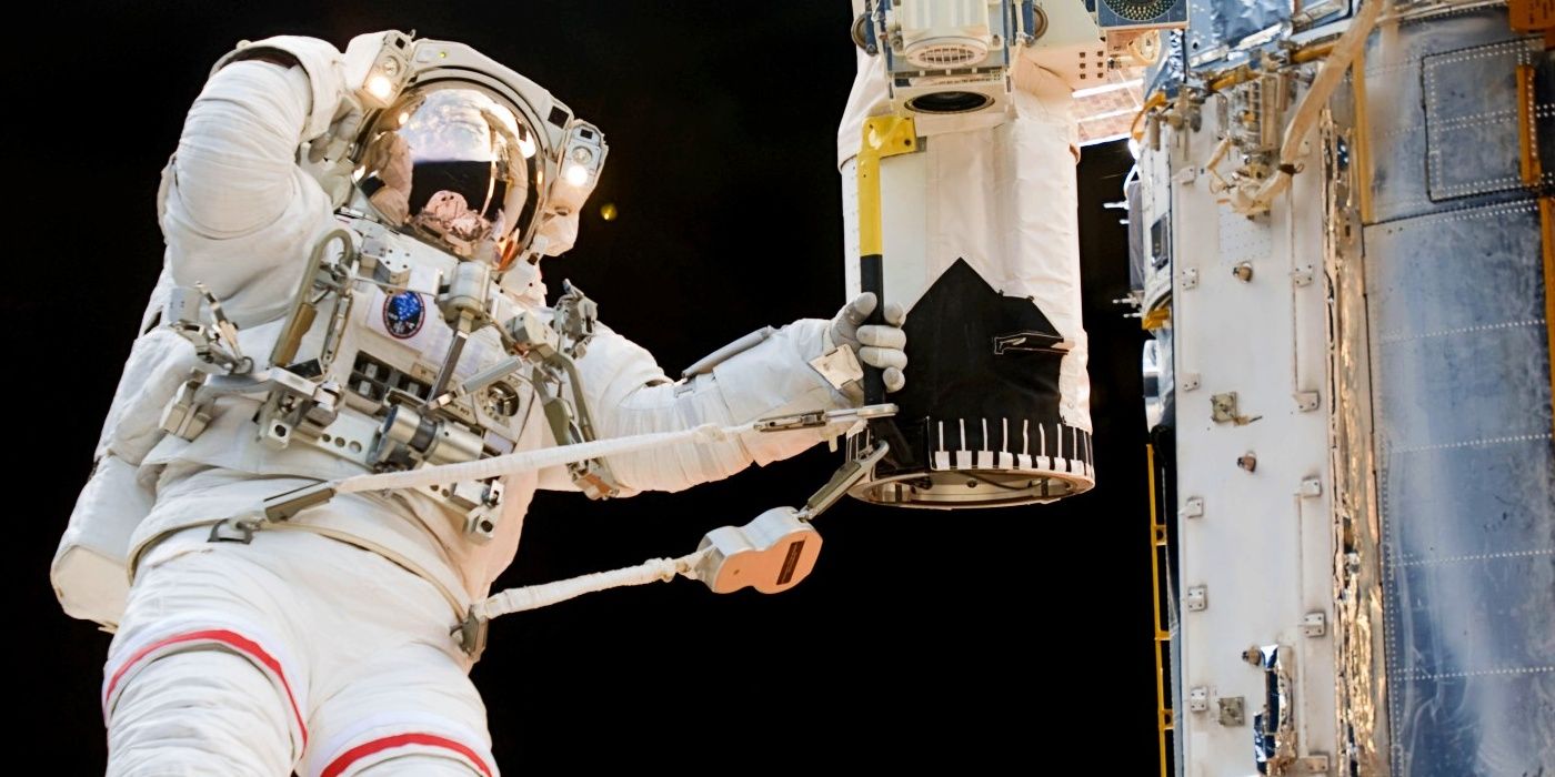 Astronaut in space servicing Hubble Space Telescope