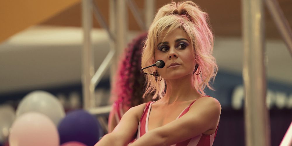 Bunny wears a headset and a pink and white top in Physical