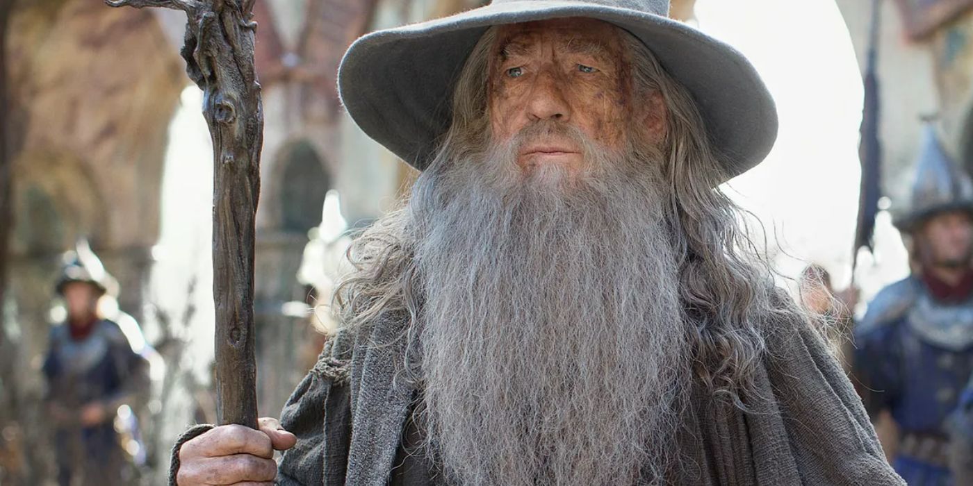 Gandalf the Grey holding his staff with soldiers behind him in The Lord of the Rings