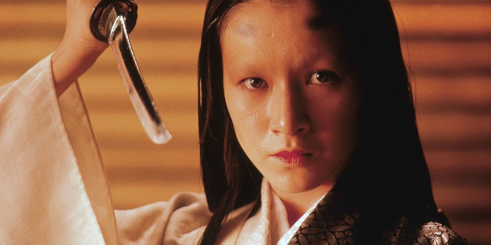 Lady Kaede desembainha uma lâmina de seu quimono.