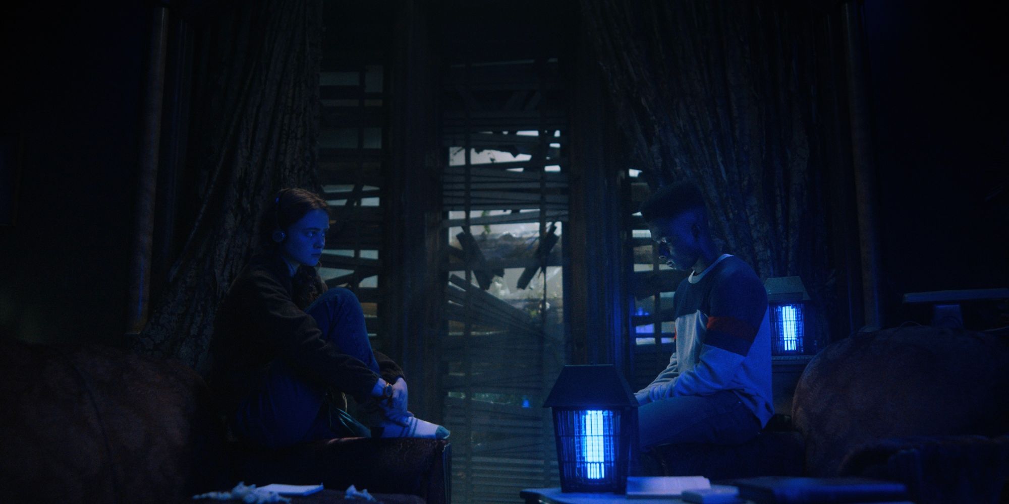 Sadie Sink as Max and Caleb McLaughlin as Lucas in Stranger Things season 4 sitting in a dark room