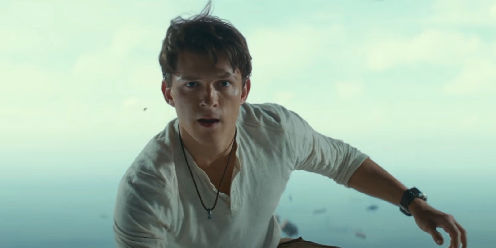 Tom Holland como Nathan Drake en la bodega de carga abierta de un avión en una película desconocida