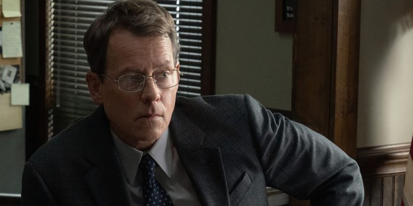 Greg Kinnear in a suit at his desk wearing glasses in a scene from Black Bird.