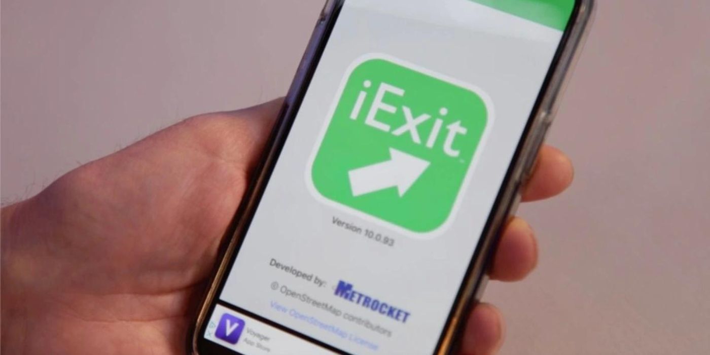 A hand holding a phone with the iExit app.