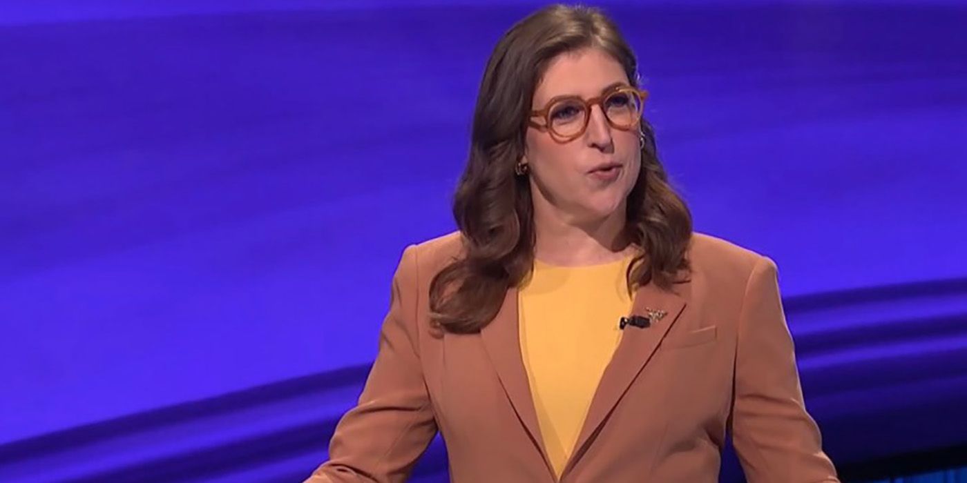 Mayim Bialik in a beige suit as host of Jeopardy!