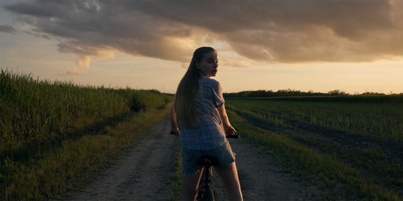 Jessica Roach in Black Bird in a flashback scene, looking behind her as she rides her bike alone at night.