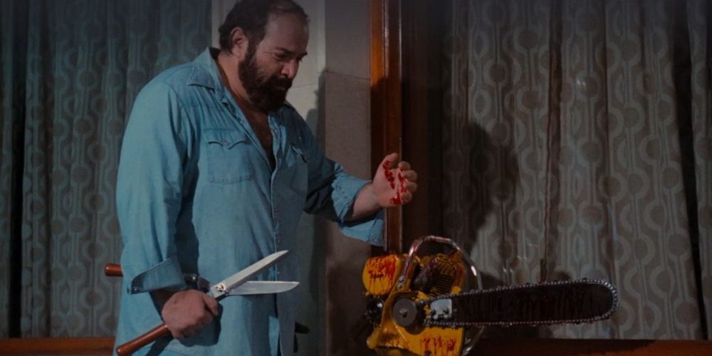 A man holds scissors by a bloody chainsaw in Pieces