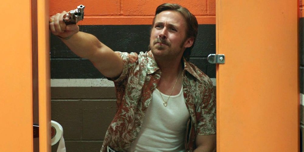 March holds a gun on the toilet in The Nice Guys
