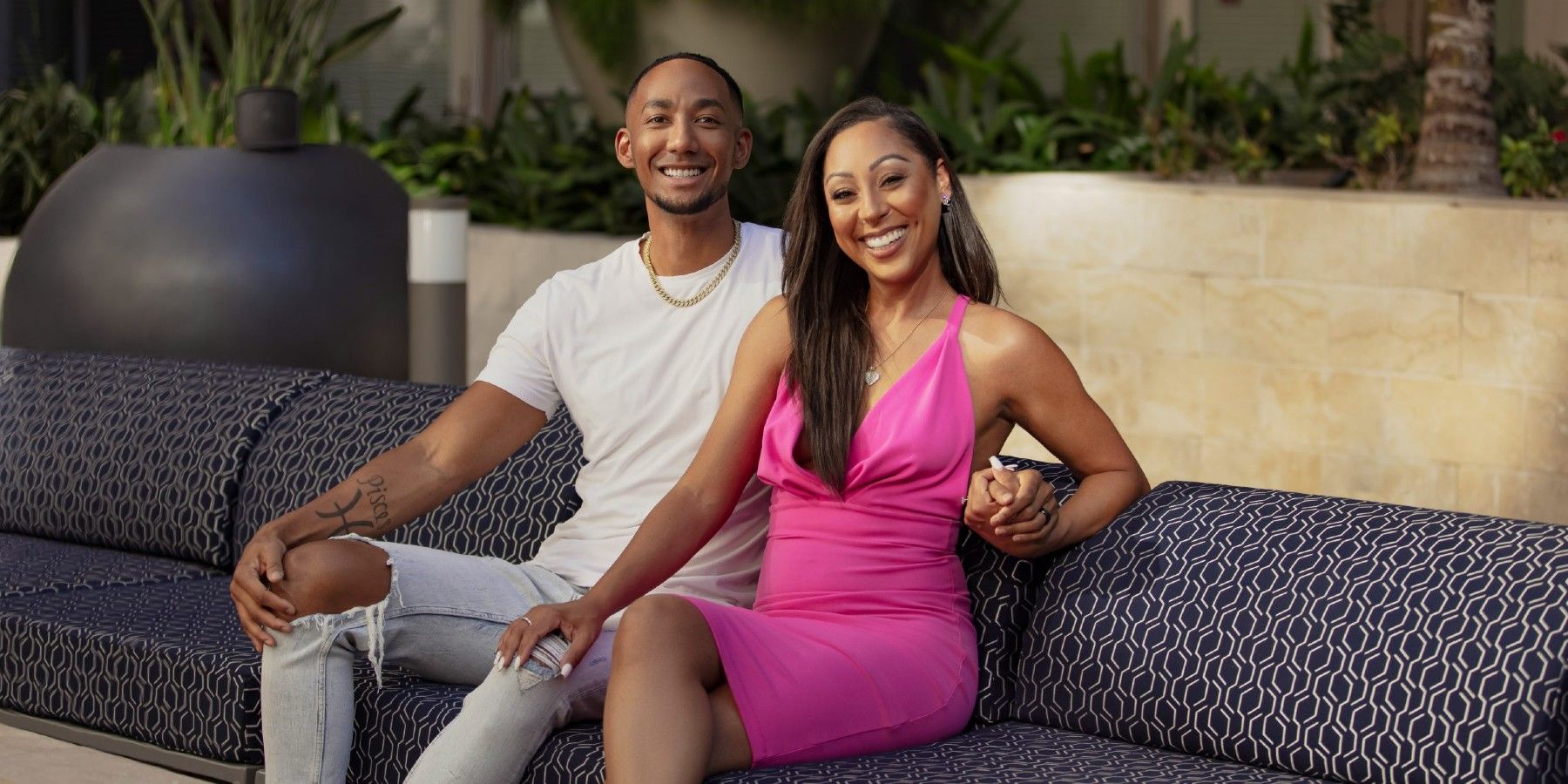 Stacia and Nate from Married at First Sight sitting posing on a couch for a promo shot