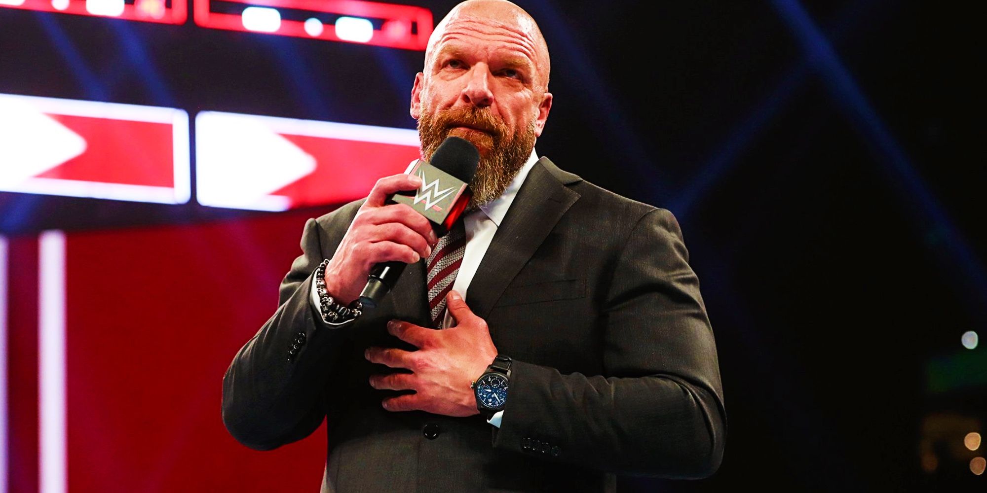 triple h on the microphone in suit at wwe