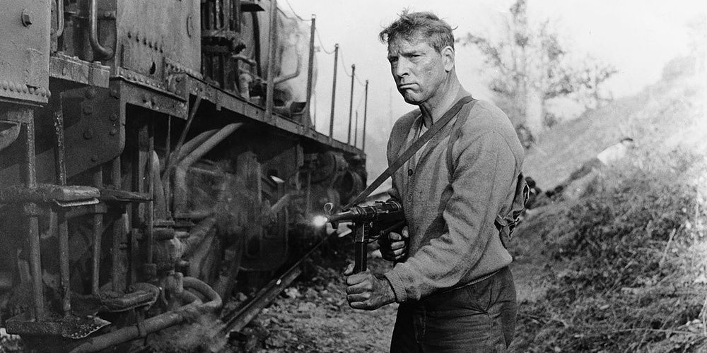 A man with a gun next to a destroyed train in The Train 1965 Cropped 1
