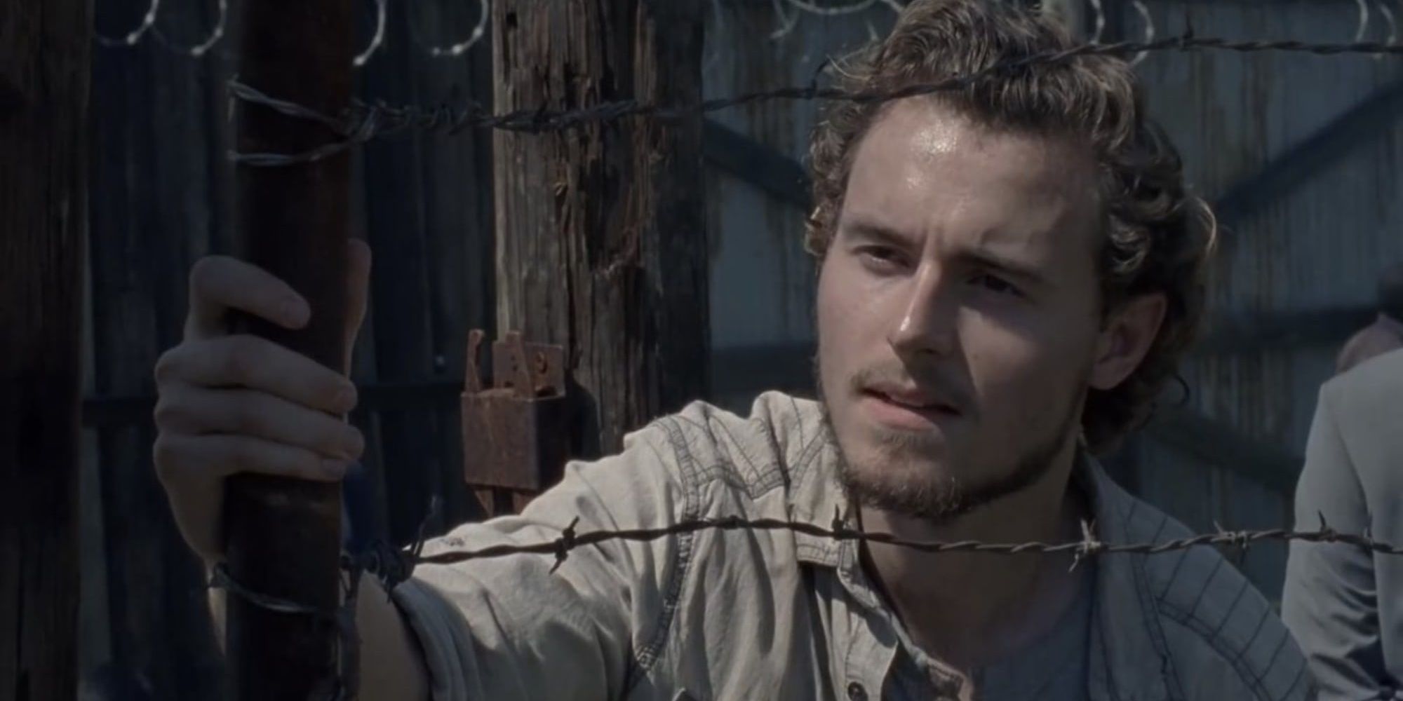 Alden behind a fence in The Walking Dead 