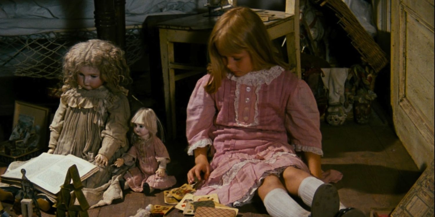 Alice sentada no chão com brinquedos e bonecas na versão de 1988 de Alice no País das Maravilhas
