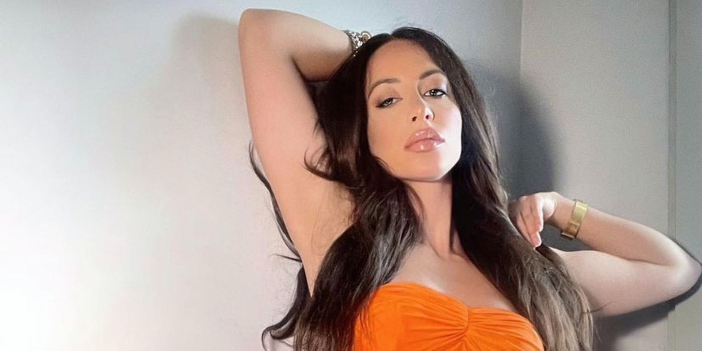 Amira Lollysa From 90 Day Fiancé Season 8 posing in orange strapless dress