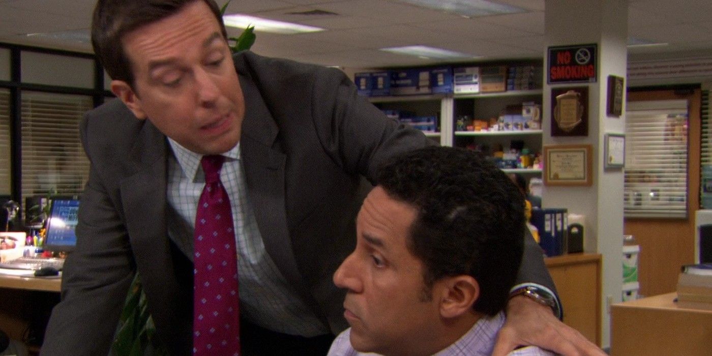 Andy leaning over Oscar at his desk in The Office