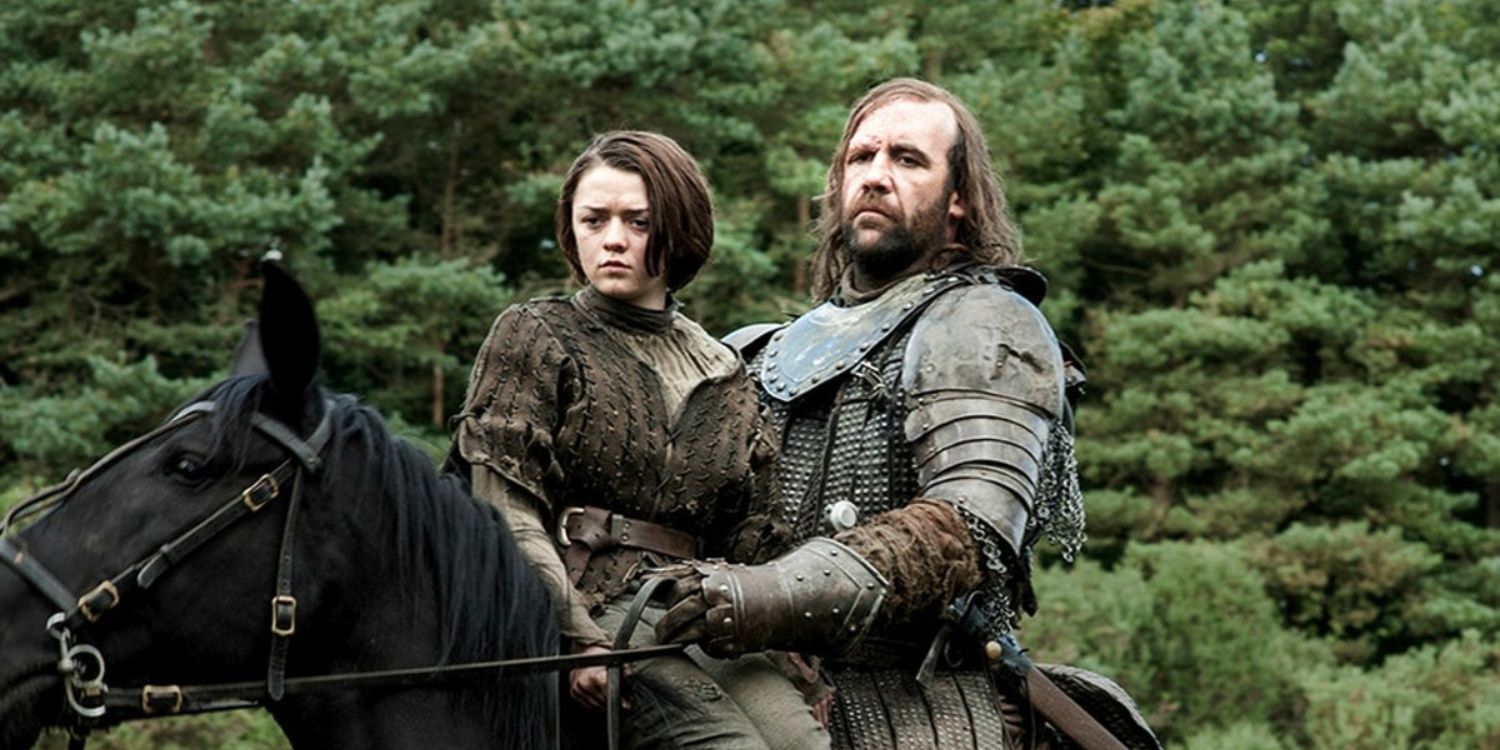 Arya riding on a horse with The Hound.