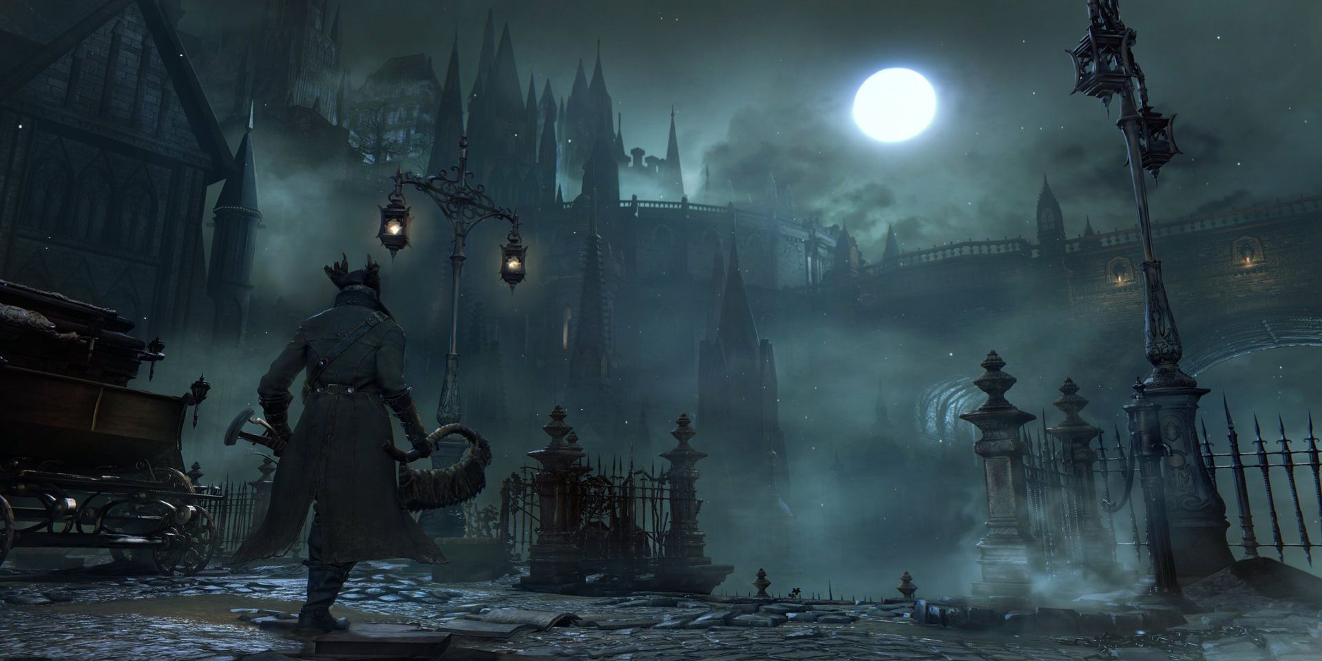 The city of Yarnham lit by lampposts at night in Bloodborne.