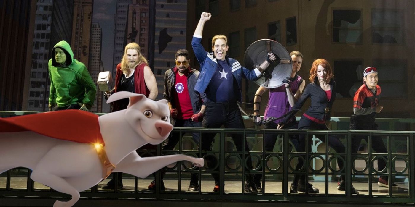 The cast of Rogers The Musical poses with an image of Krypto the dog flying in front of them