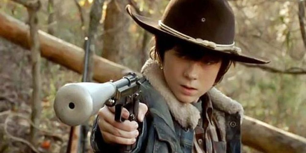 Carl Grimes aponta uma arma em The Walking Dead 