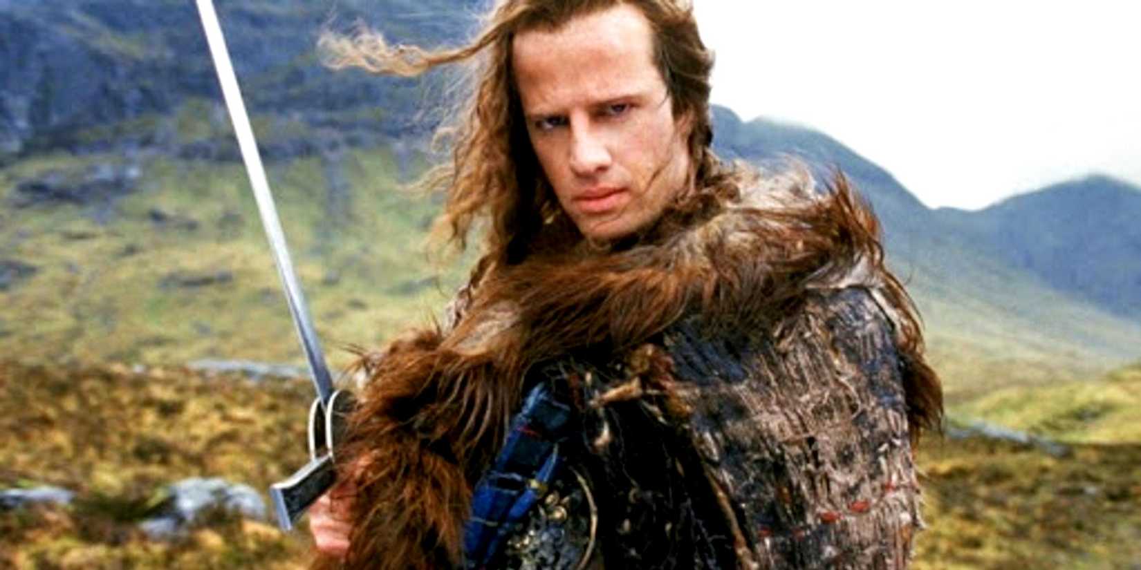 Christopher Lambert as Connor MacLeod holding a sword on a mountain in Highlander.