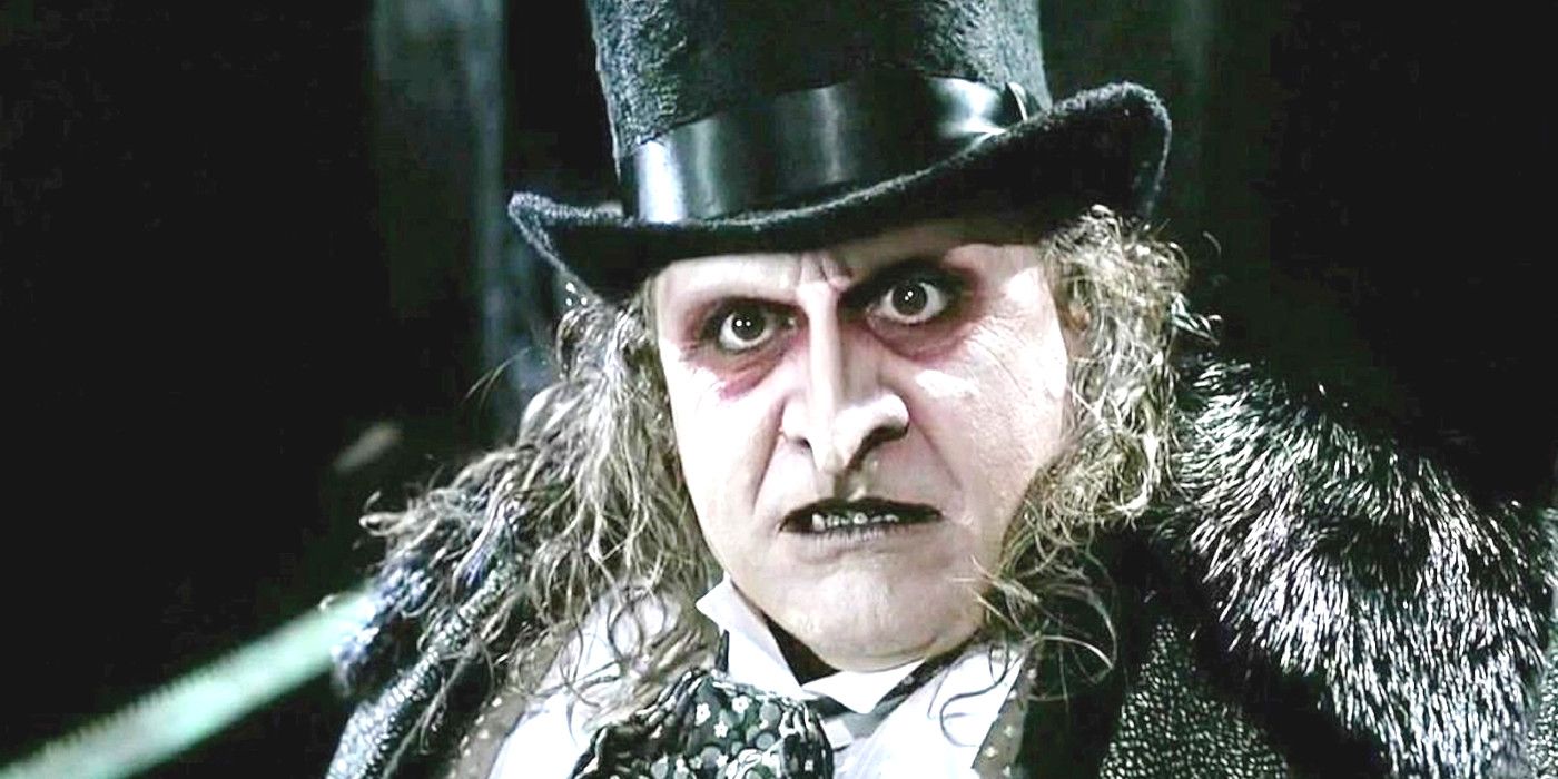 Penguin in Batman Returns in a top hat, snarling and showing black teeth