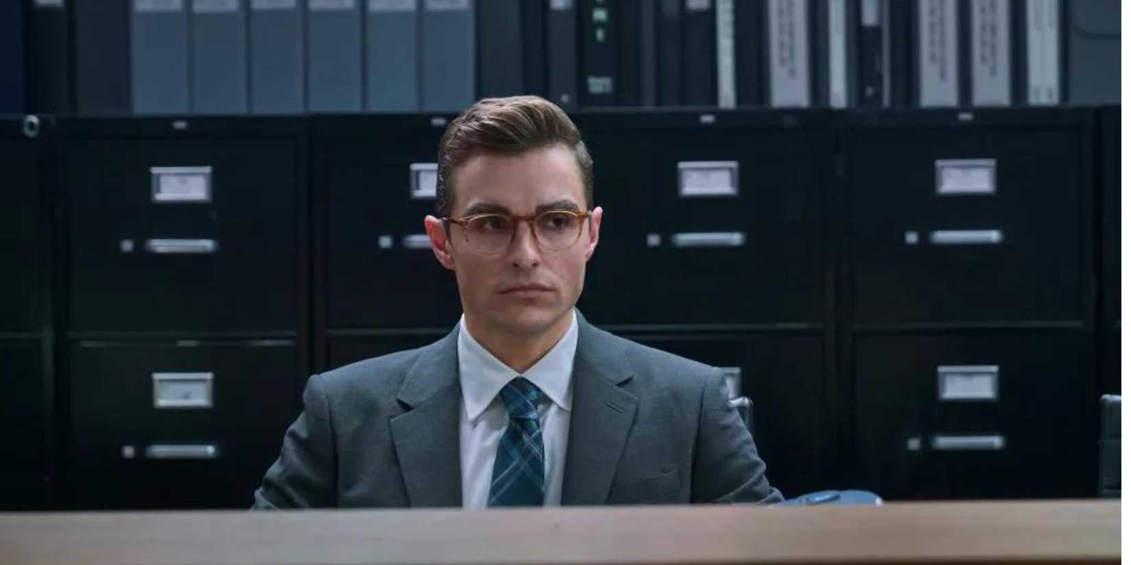 Dave Franco as Seth sitting at a desk in Day Shift