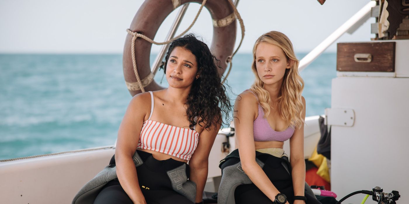 Two young women sitting in a boat with their diving gear in Dive Club