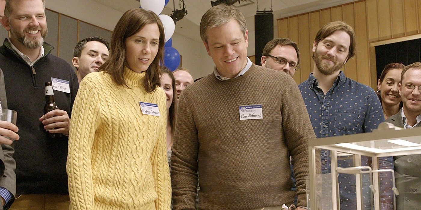Matt Damon and Kristen Wiig in Downsizing looking at an experiment in Dowsizing
